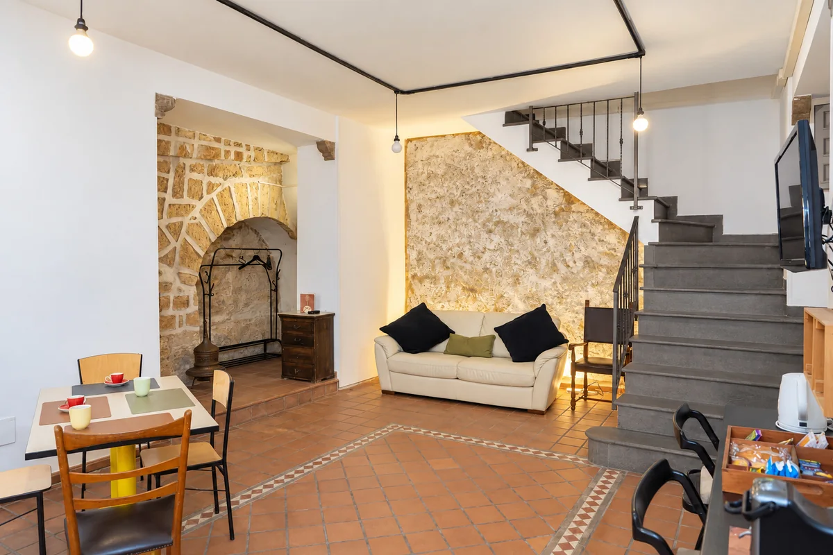 Il salotto con l'arco in pietra e la scala per il piano superiore